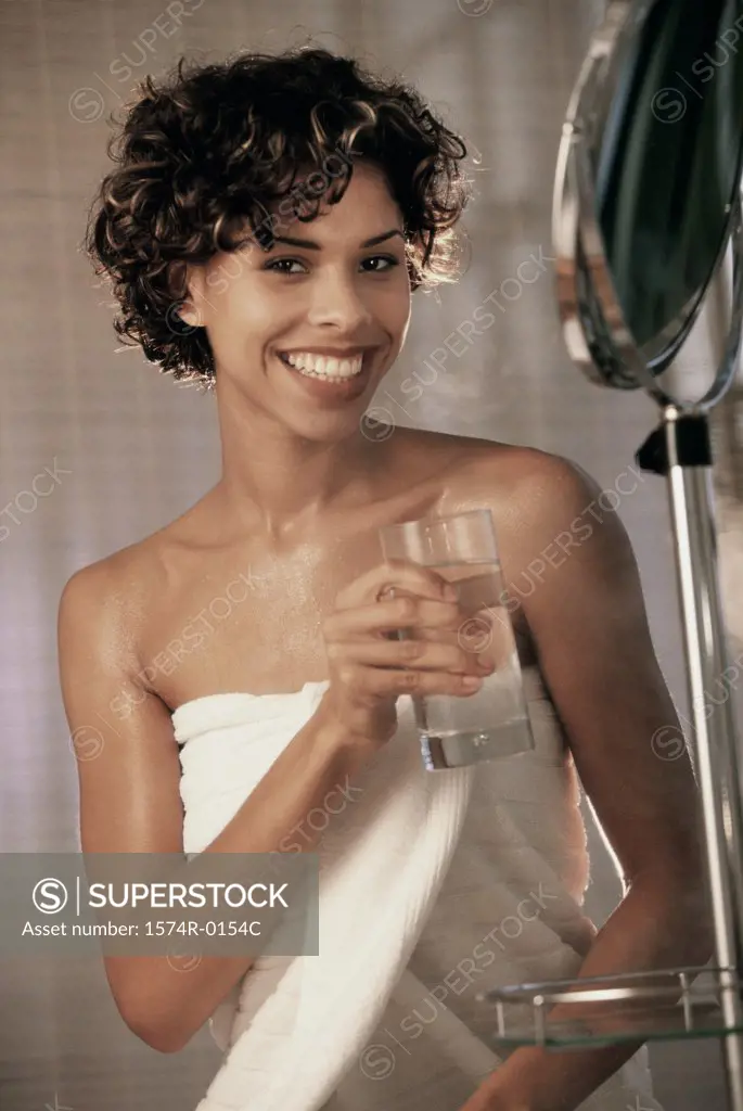 Portrait of a young woman holding a glass of water