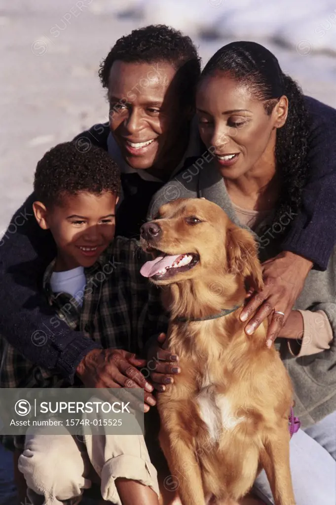 Close-up of parents and their son playing with a dog