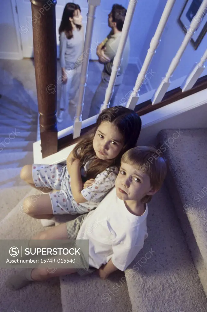 High angle view of a brother and sister sitting on stairs