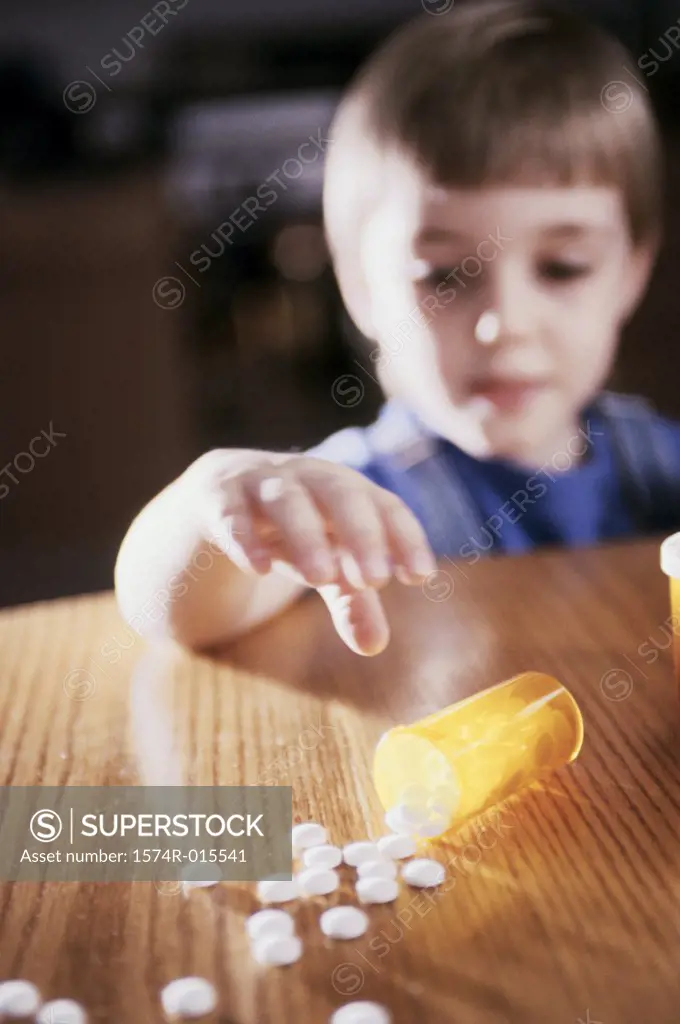 Close-up of a boy reaching out for pills