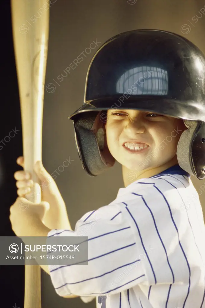 Boy in a baseball uniform holding a baseball bat
