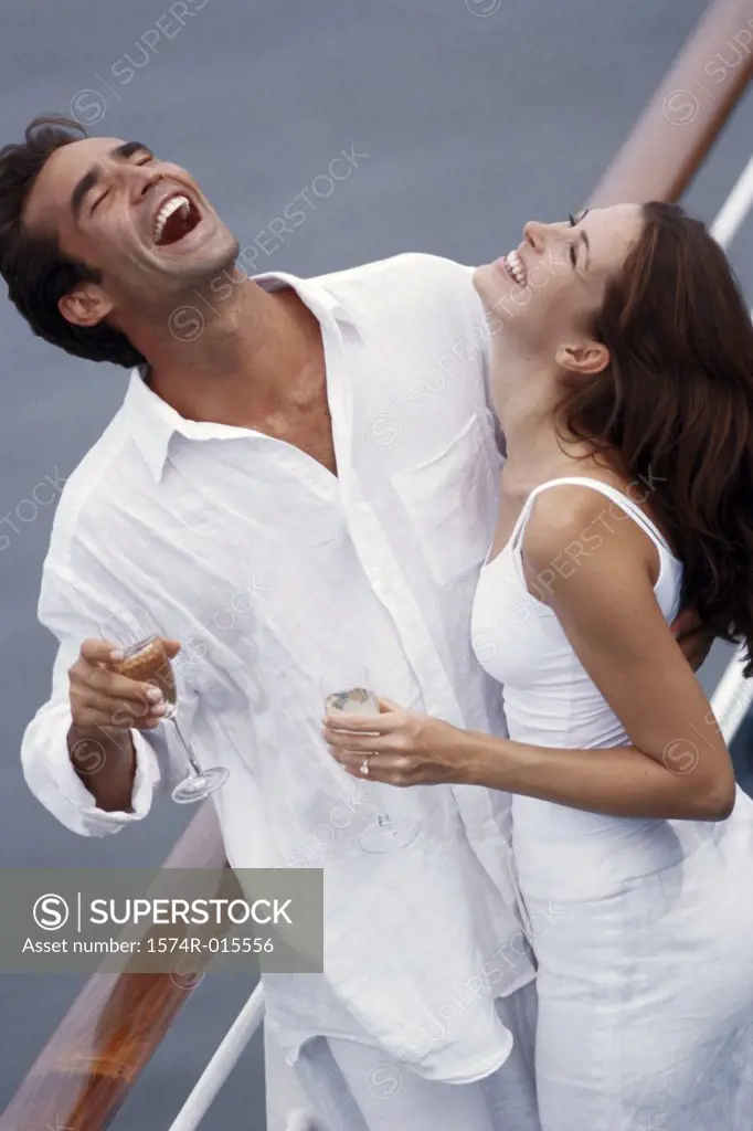 High angle view of a young couple standing on the deck of a cruise ship and laughing