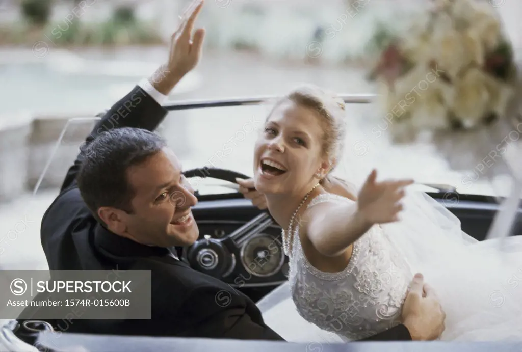 Newlywed couple sitting in a convertible car