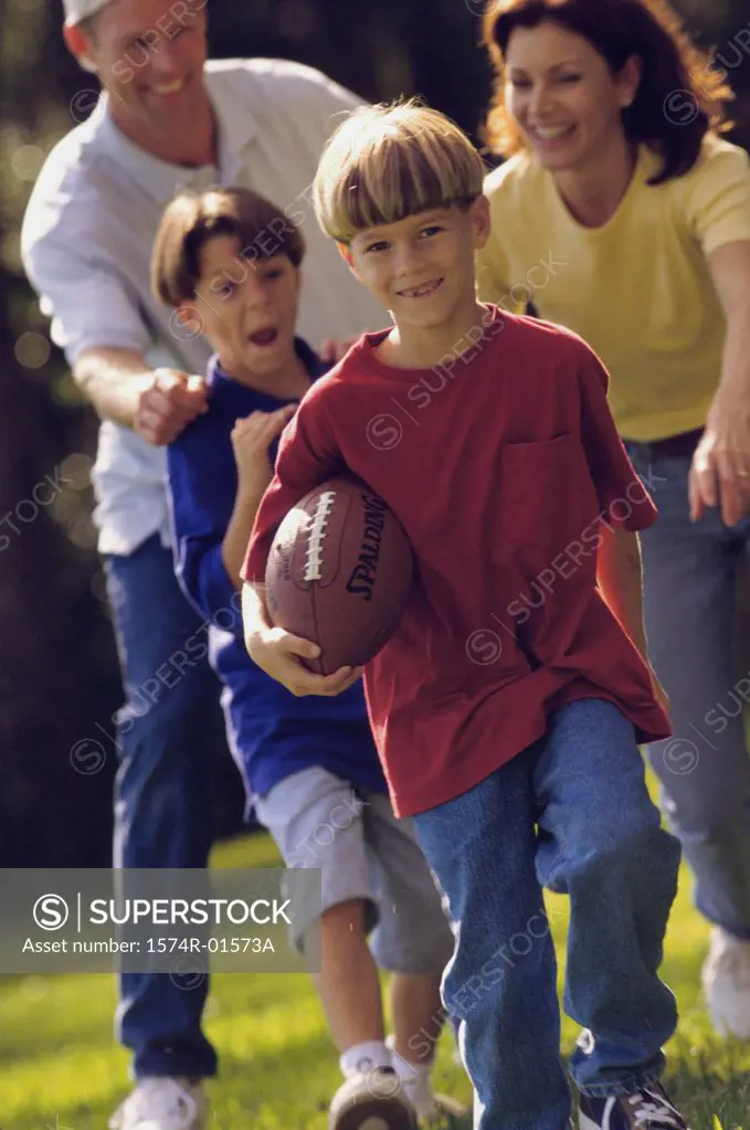 Couple playing football with their sons