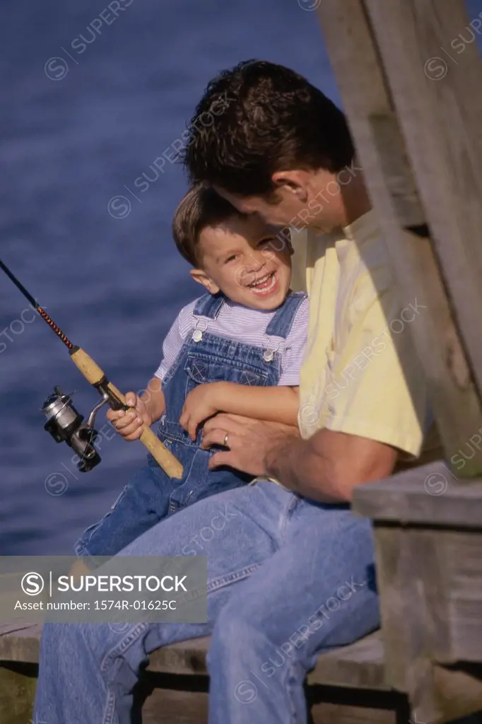 Father and son fishing from a dock