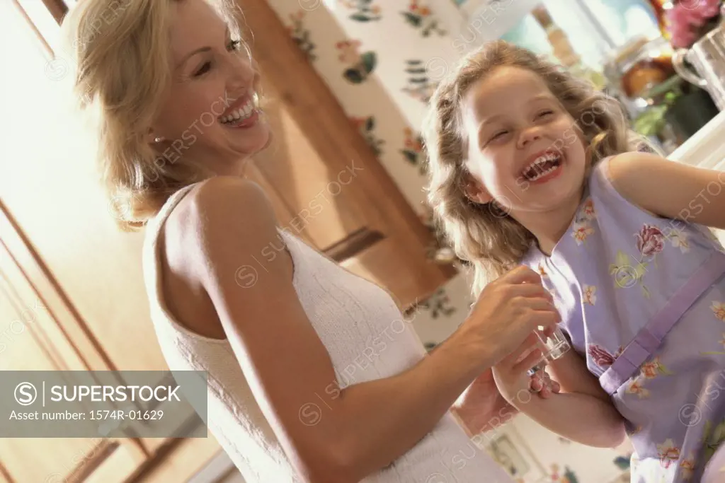 Mother and daughter laughing in the kitchen