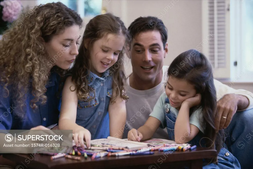 Father and mother coloring with their two children