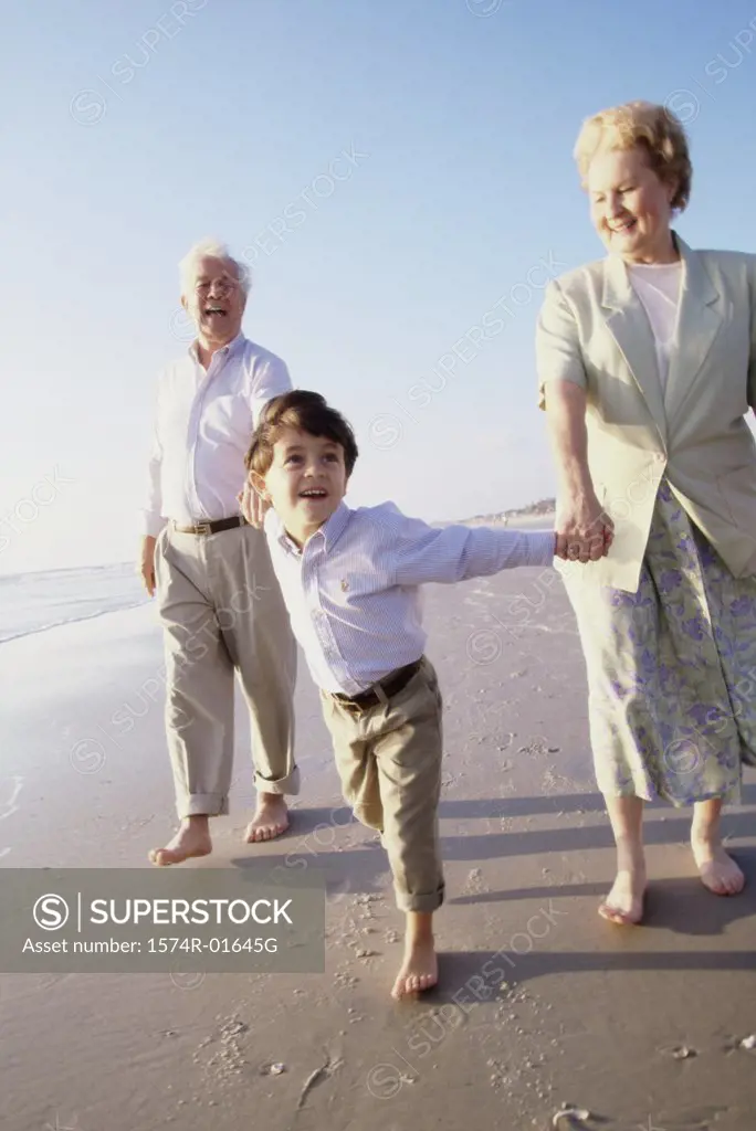 Grandson walking at the beach with his grandparents
