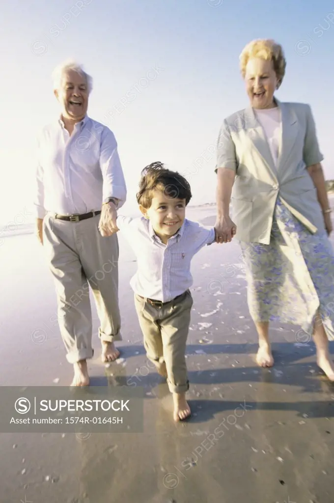 Grandson walking at the beach with his grandparents