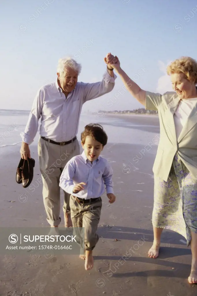 Boy playing on the beach with his grandparents