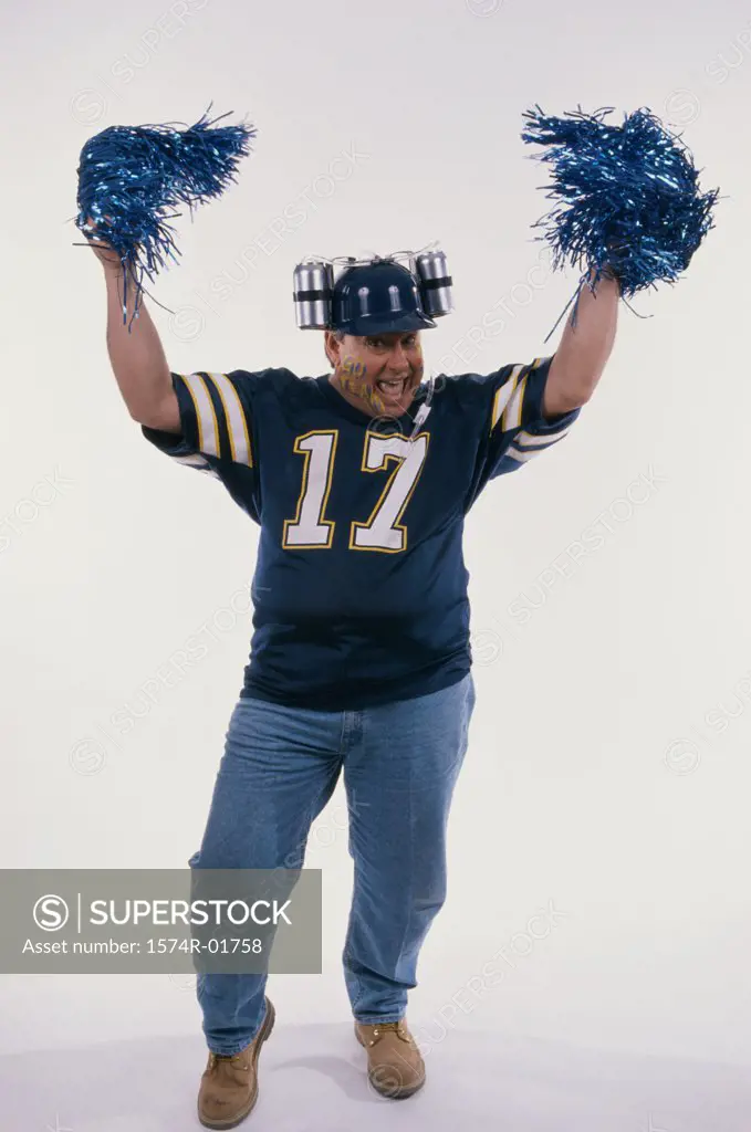 Portrait of a sports fan holding pom-pom in his hands