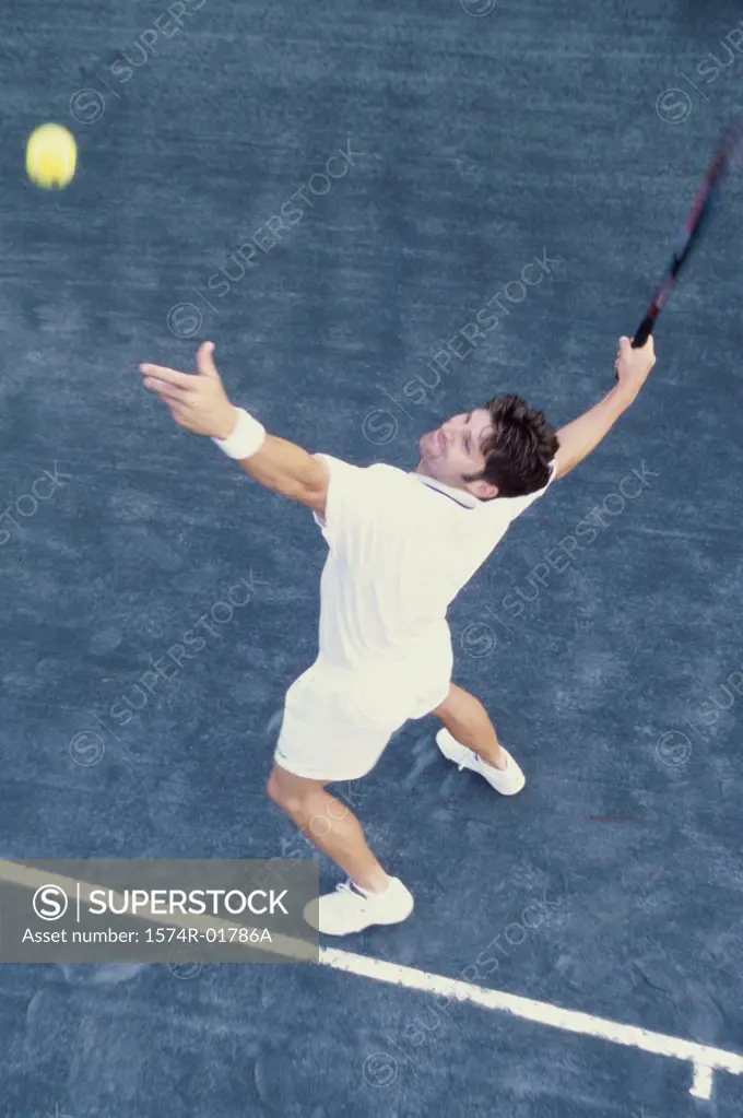 High angle view of man serving a tennis ball