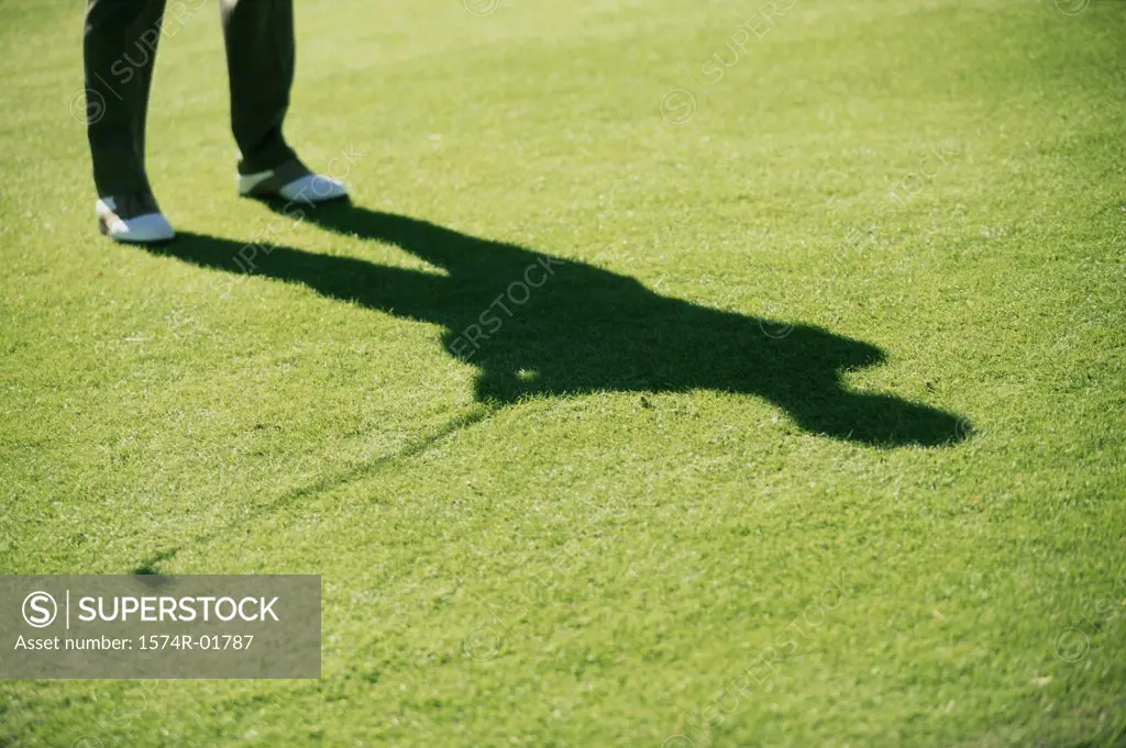 Shadow of a person playing golf