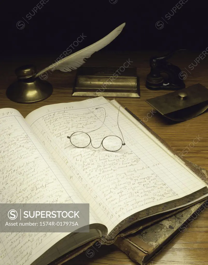 Close-up of an accounting ledger with eyeglasses and a quill pen, USA