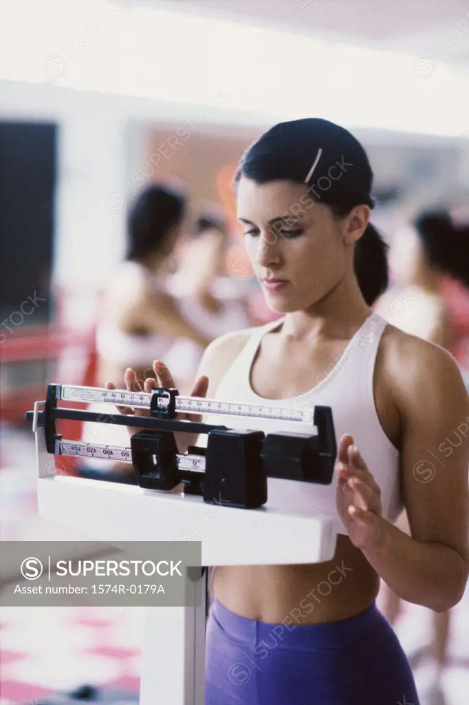 Young woman standing on a weighing scale