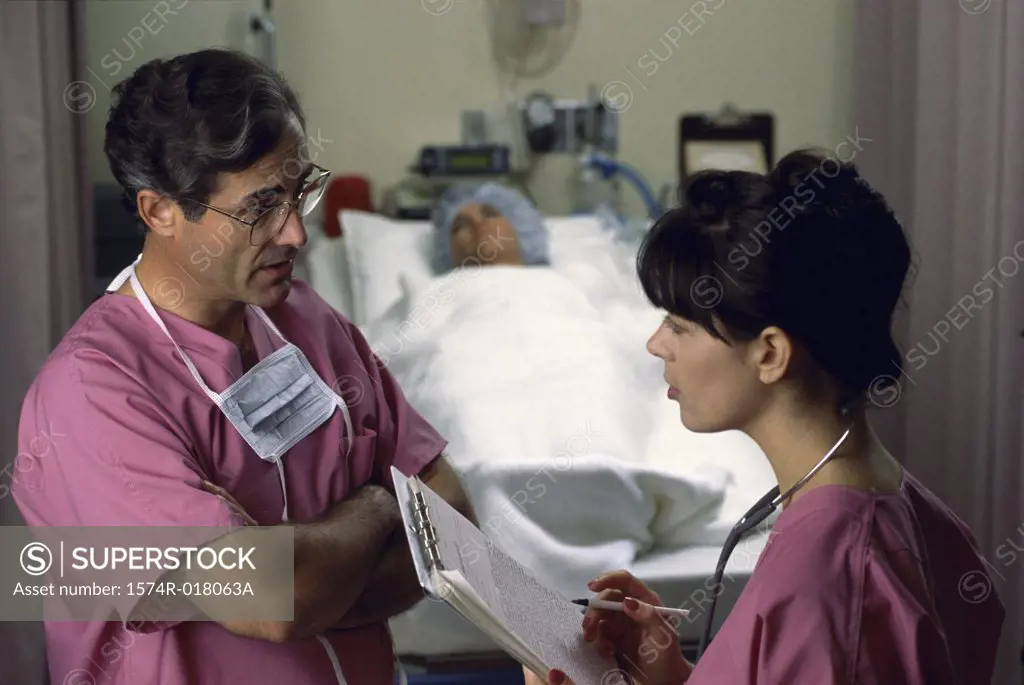 Side profile of a male doctor and a female doctor talking