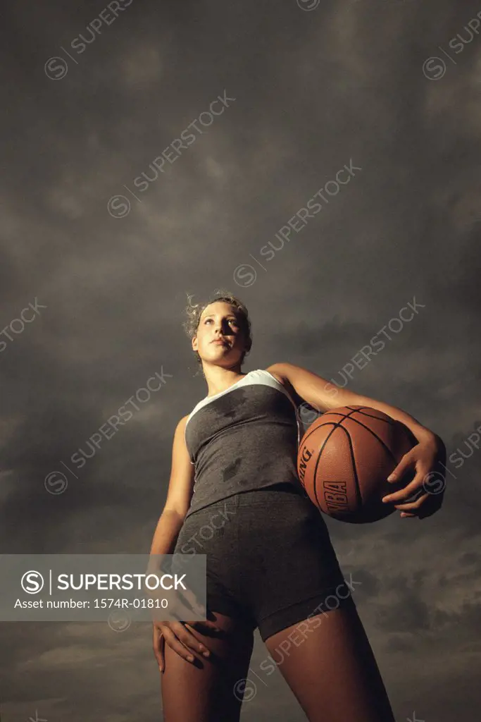 Low angle view of a young woman holding a basketball