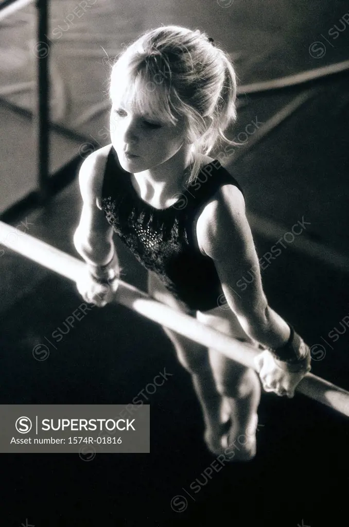 Girl performing gymnastics on uneven parallel bars