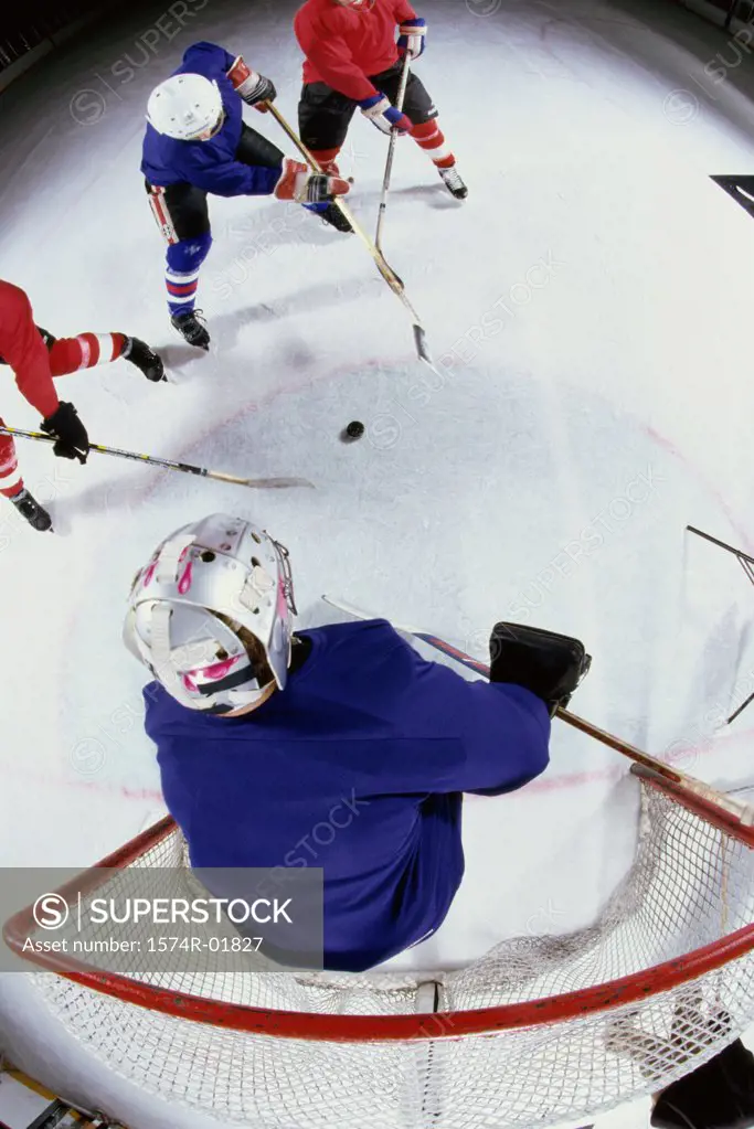 High angle view of ice hockey players surrounding the goal