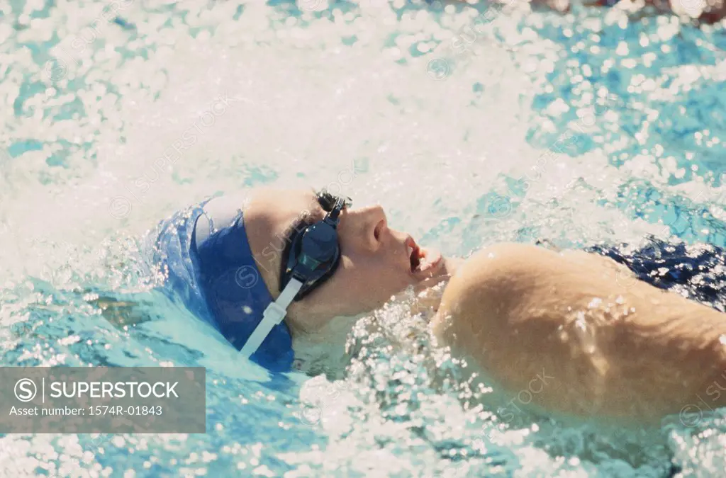 Side profile of a young woman swimming in a swimming pool
