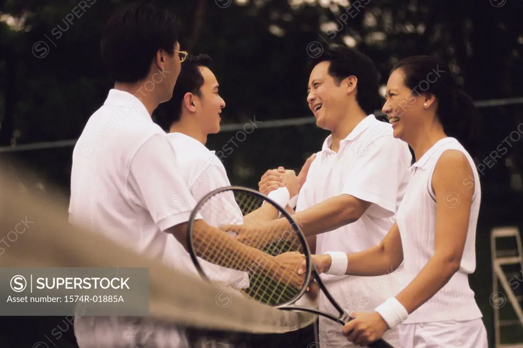 Side profile of tennis players shaking hands over a net