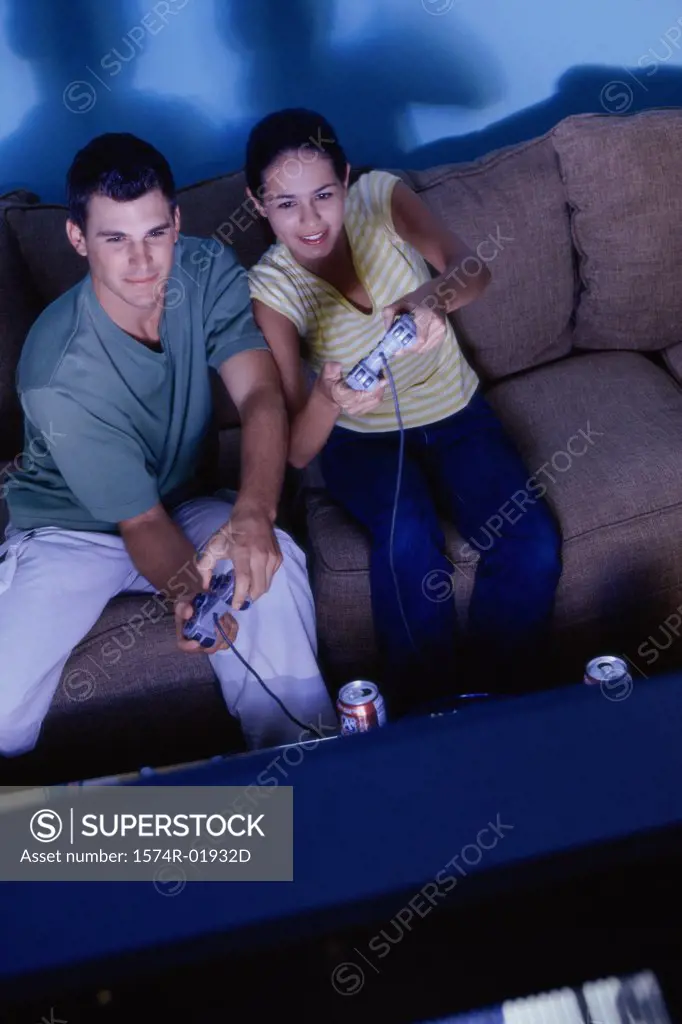 Young couple sitting on a couch playing video games