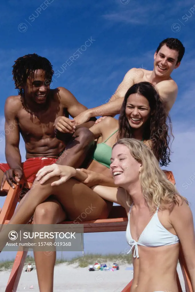 Low angle view of a group of teenagers sitting on a lifeguard tower