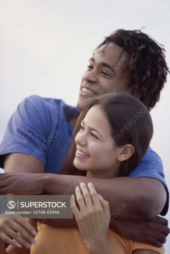 Young man holding a young woman from behind