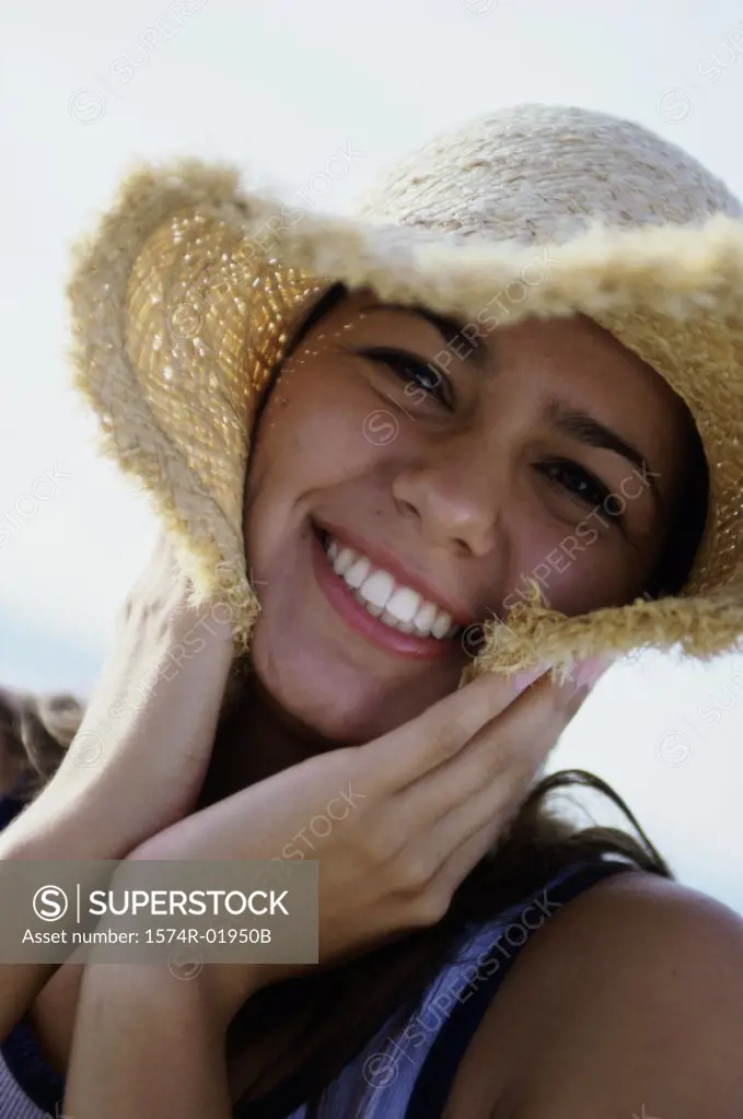 Portrait of a teenage girl wearing a straw hat smiling