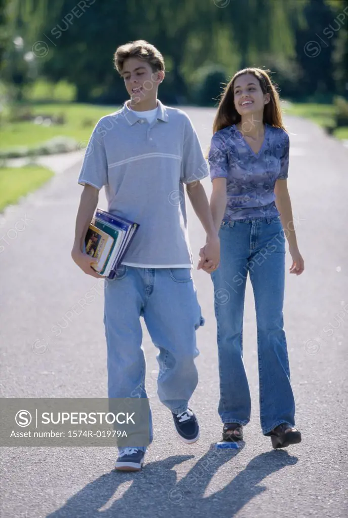 Teenage couple holding hands walking outdoors