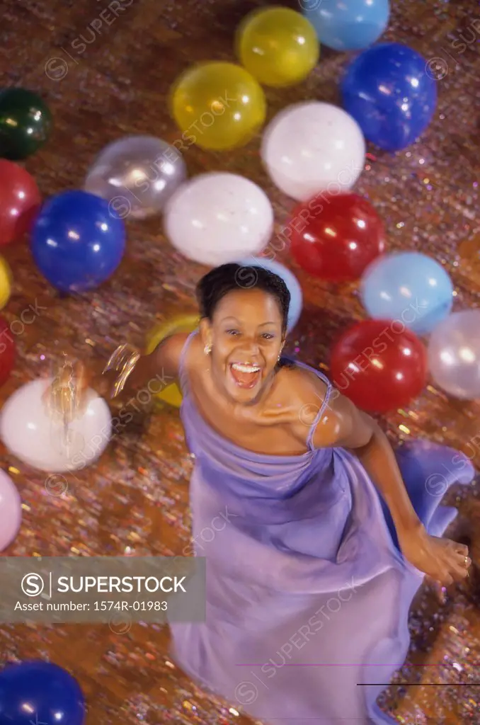 Portrait of a young woman dancing amongst balloons