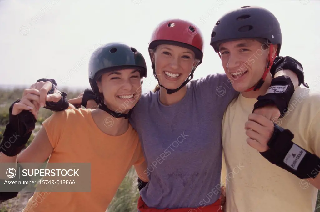 Portrait of a group of three teenagers wearing helmets smiling