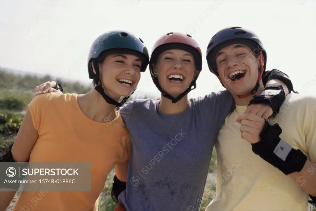 Portrait of two teenage girls and a teenage boy smiling