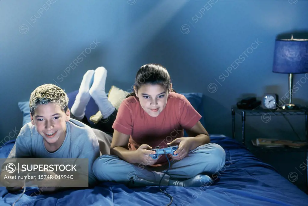 Teenage boy and a teenage girl playing video games