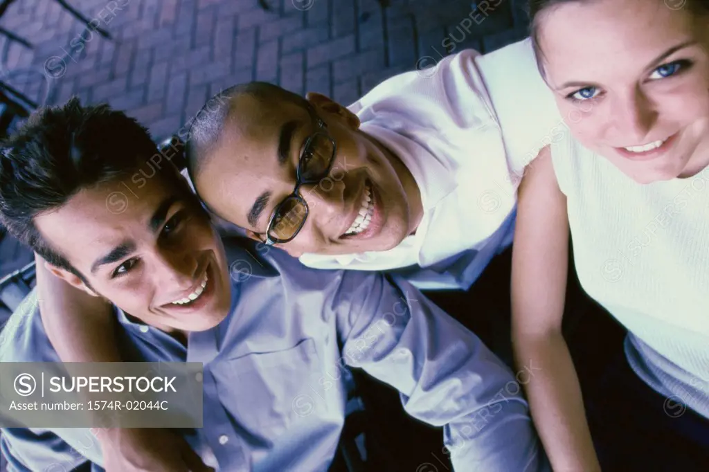 Portrait of two young men and a young woman smiling