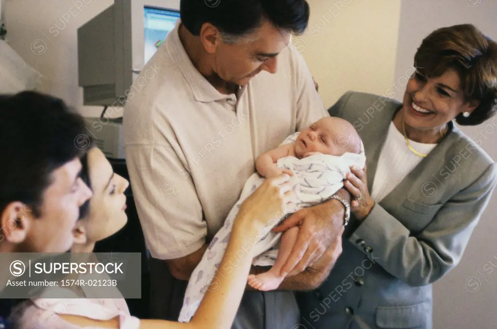 Grandparents carrying their baby boy in the hospital
