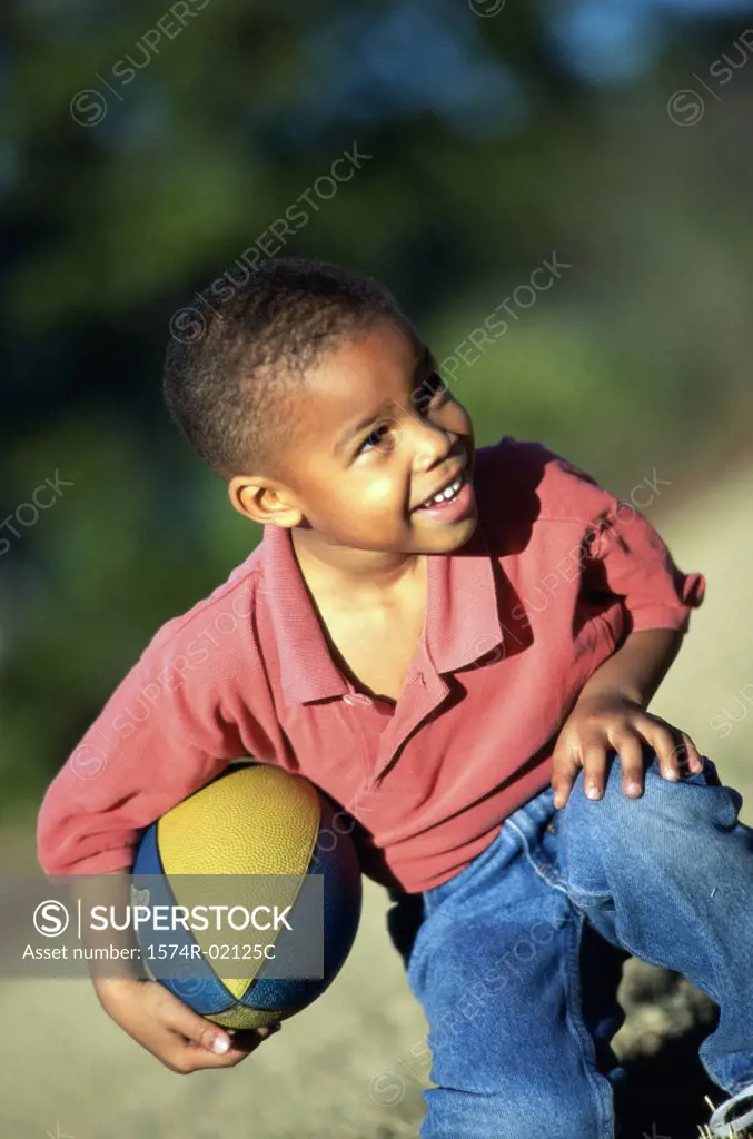 Boy kneeling with a rugby ball