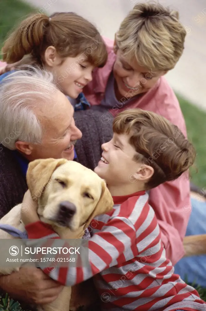 Grandparents with their grandson and granddaughter holding their dog