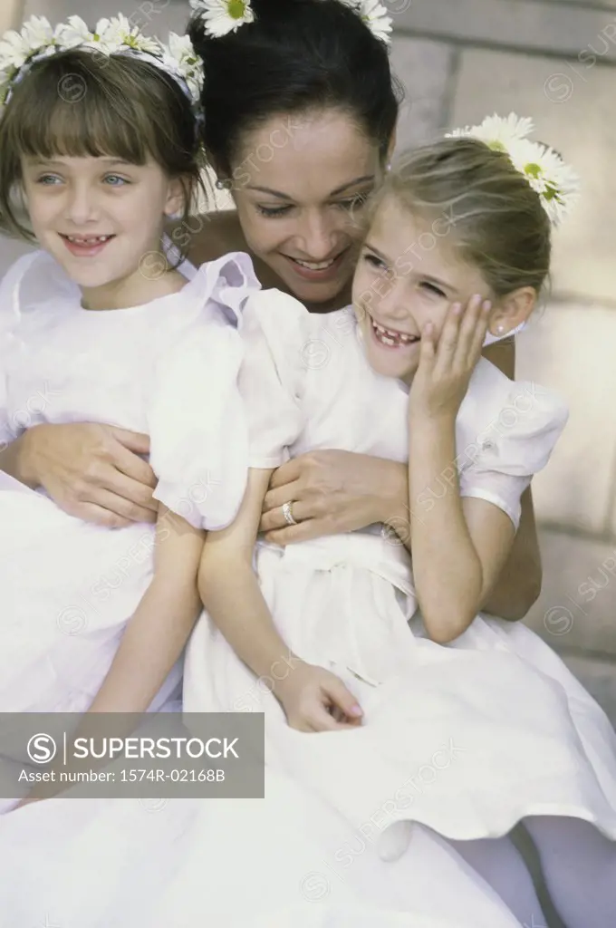 Bride hugging two flower girls