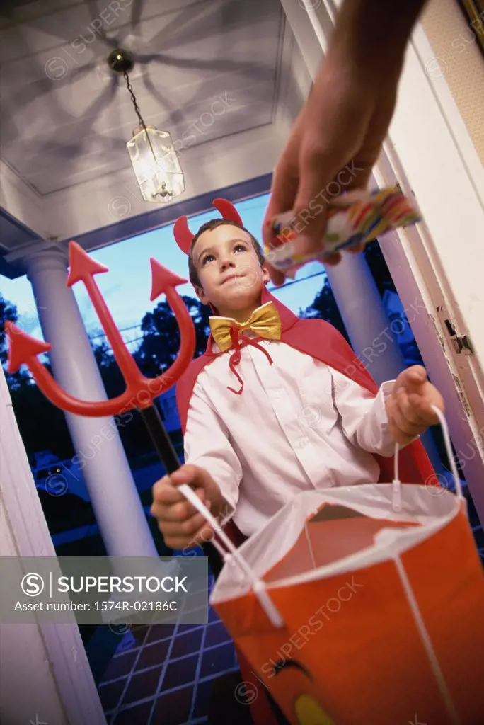 Low angle view of a boy dressed as the devil on Halloween