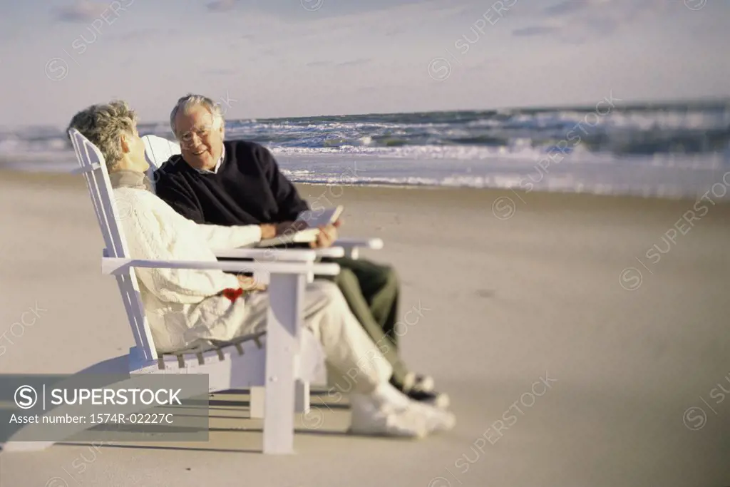 Senior couple sitting together on the beach