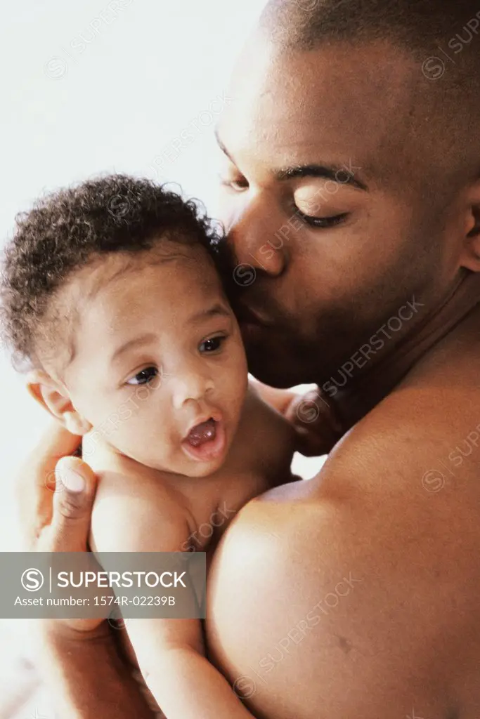 Close-up of a father kissing his baby boy