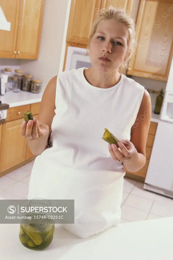 Portrait of a pregnant woman eating pickles