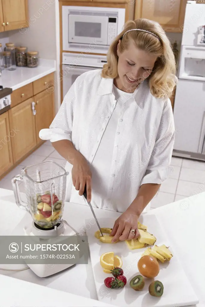 Pregnant woman cutting fruit