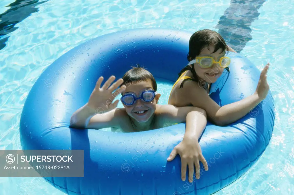 High angle view of a boy and a girl in an inflatable ring in a swimming pool