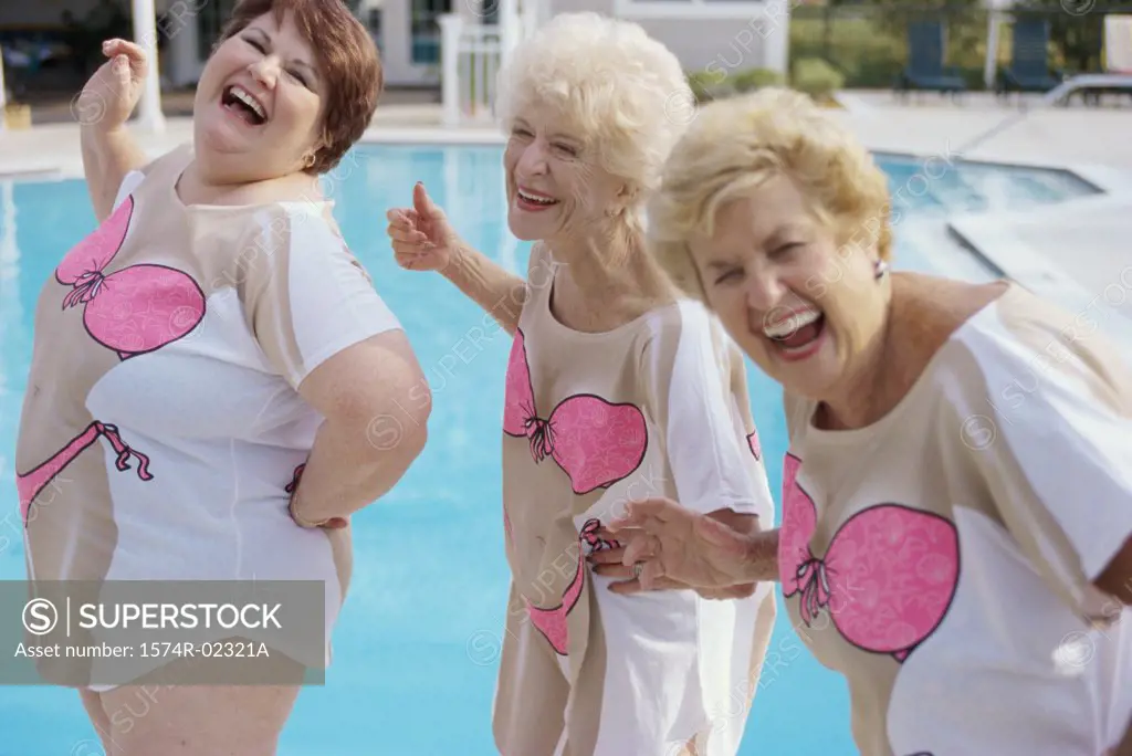 Three senior women standing near a swimming pool
