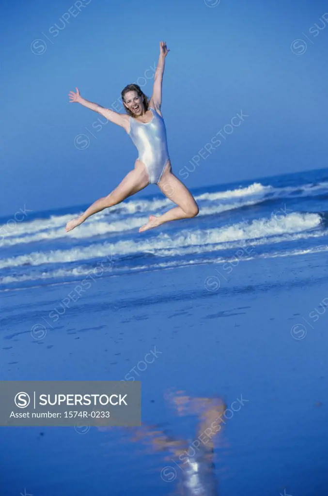 Portrait of a young woman jumping at the beach