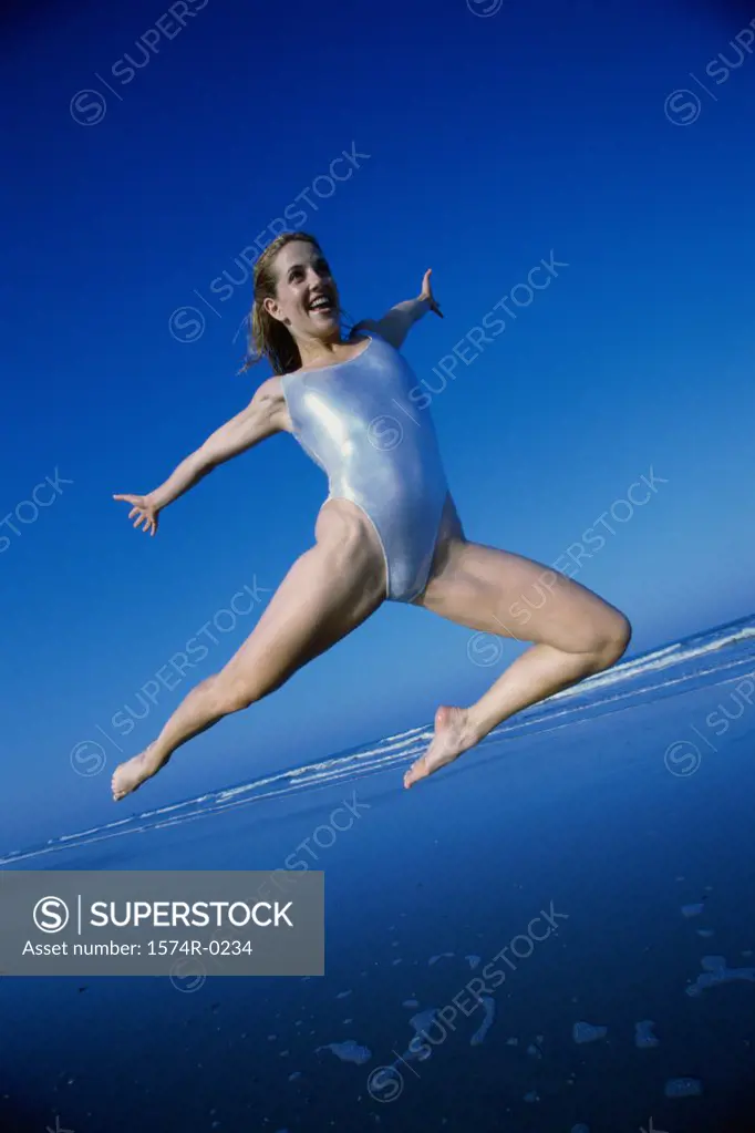Young woman jumping at the beach