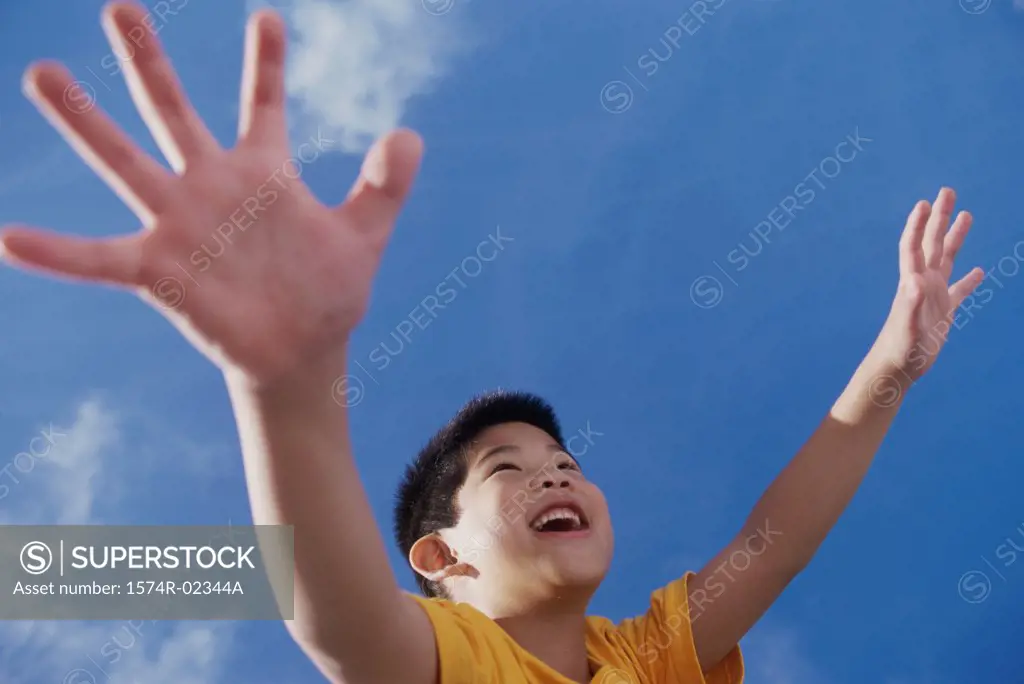 Low angle view of a boy with his arms outstretched