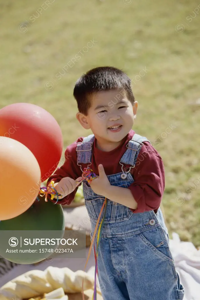 Portrait of a boy holding balloons